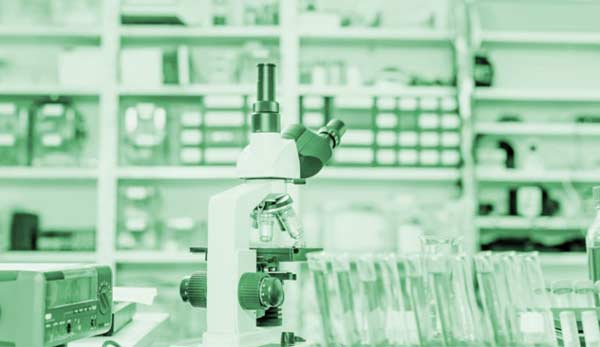 A microscope stands on a laboratory counter